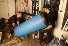 Handwerker tragen den alten Speicher aus dem Keller.