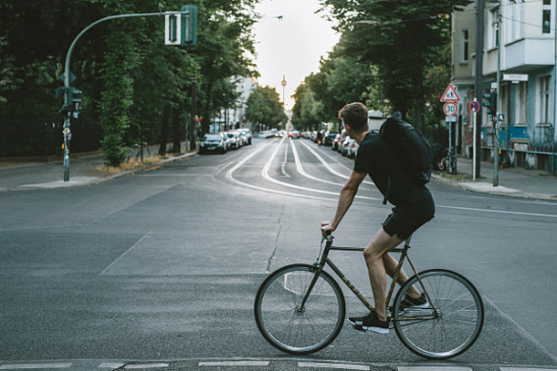 Auf dem Bild ist ein Fahrradfahrer in der Stadt zu sehen.