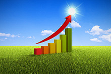 Balkendiagramm zur Energieeffizienz auf grüner Wiese mit aufwärts zeigendem Pfeil - Symbolbild als Ziel vom Energiesparen.