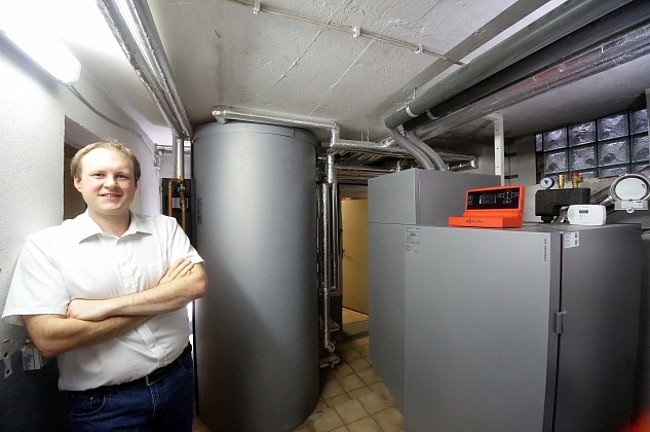 Carsten Tamm steht vor seiner Heizungsanlage im Keller.