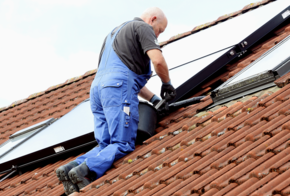 Handwerker schraubt Solarleitung ab.