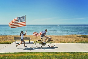 Fahrradfahrer und Joggerin mit USA-Flaggen