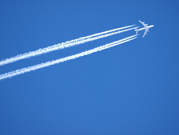 Flugzeug in großer Höhe mit Kondensstreifen