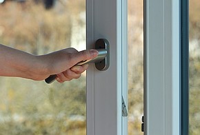 Person schließt ein Fenster.