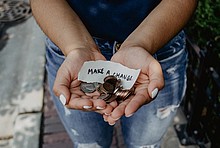 Hände mit Mützen und Zettel &quot;Make a Change&quot;